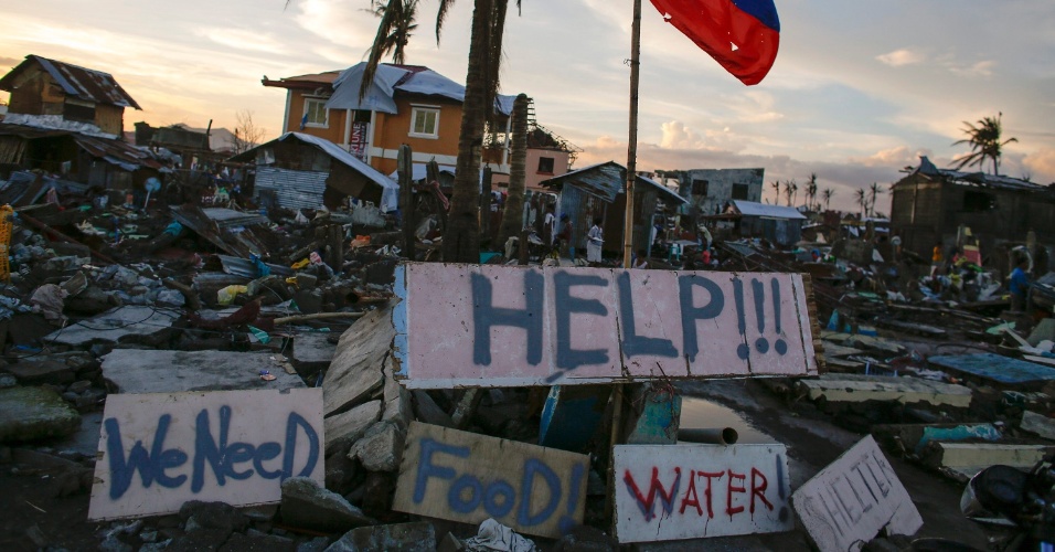24nov2013---sobreviventes-de-tufao-espalham-placas-com-pedidos-de-socorro-agua-e-comida-na-cidade-de-tacloban-nas-filipinas-1385326940444_956x500